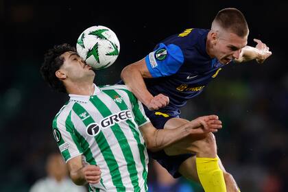 Johnny Cardoso del Betis, derecha, se enfrenta por el balón ante Mark Zabukovnik del Celje durante la Conference League en el estadio Benito Villamarin en Sevilla, España el jueves 7 de noviembre de 2024. (AP Photo/Angel Fernandez)