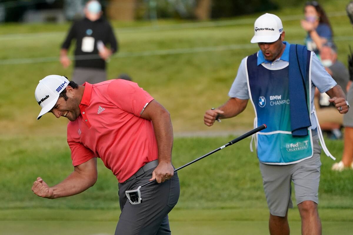 Jon Rahm, izquierda, reacciona después de hacer su putt en el primer hoyo de playoffs junto al caddie Adam Hayes durante la ronda final del torneo de golf BMW Championship en el Olympia Fields Country Club en Olympia Fields, Illinois, el domingo 30 de agosto de 2020.