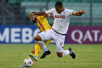 Jonathan Duche, de Aragua, ante Jose Sand, delantero de Lanús, por la Copa Sudamericana (Photo by Federico Parra / AFP)