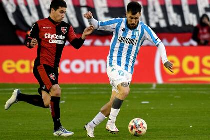 Jonathan Gómez, volante de Racing, intenta un ataque ante Newell's