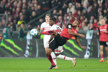 Jonathan Tah, de Leverkusen, hace un despeje frente a El Bilal Touré, de Stutgart, durante un partido de la liga alemana, el viernes 1 de noviembre de 2024 (AP Foto/Martin Meissner)