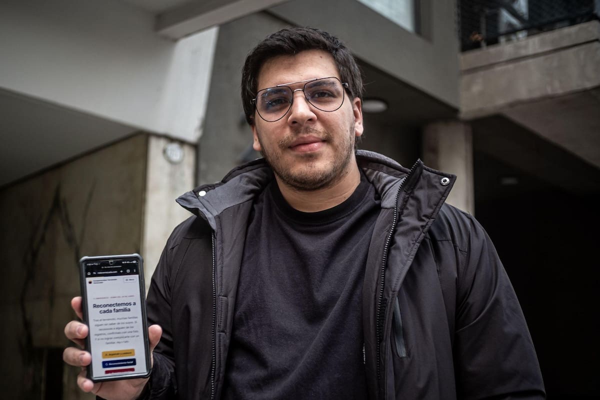 Jorge Bastidas muestra en su teléfono la plataforma Desaparecidos Terremoto Venezuela.