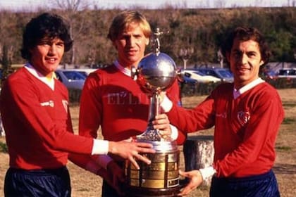 Jorge Burruchaga, actual manager del club, Enzo Trossero y Ricardo Bochini, posan en 1984 con la Copa Libertadores que el Rojo obtivo ese año. "Fue uno de los mejores equipos que integré", dijo Bochini.