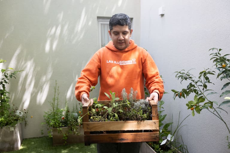 Jorge Maximiliano Ortiz carga un caj—n lleno de plantas arom‡ticas que cultivan en la huerta de la casa "lo del Tono" donde pr—ximamente comenzar‡ a vivir como parte de su proceso hacia una vida independiente. Buenos Aires, Octubre 23, 2026. (LA NACION / Nicol‡s Su‡rez)