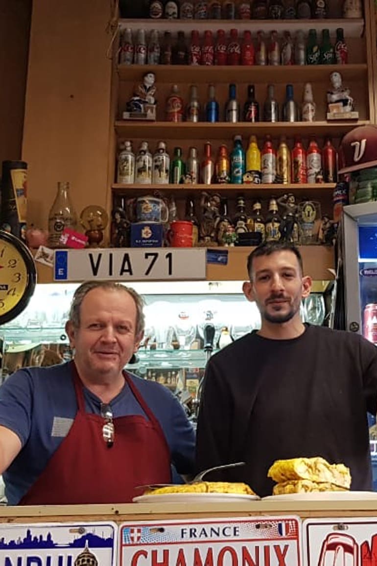 Jorge y su hijo en el mostrador repleto de recuerdos de viajes