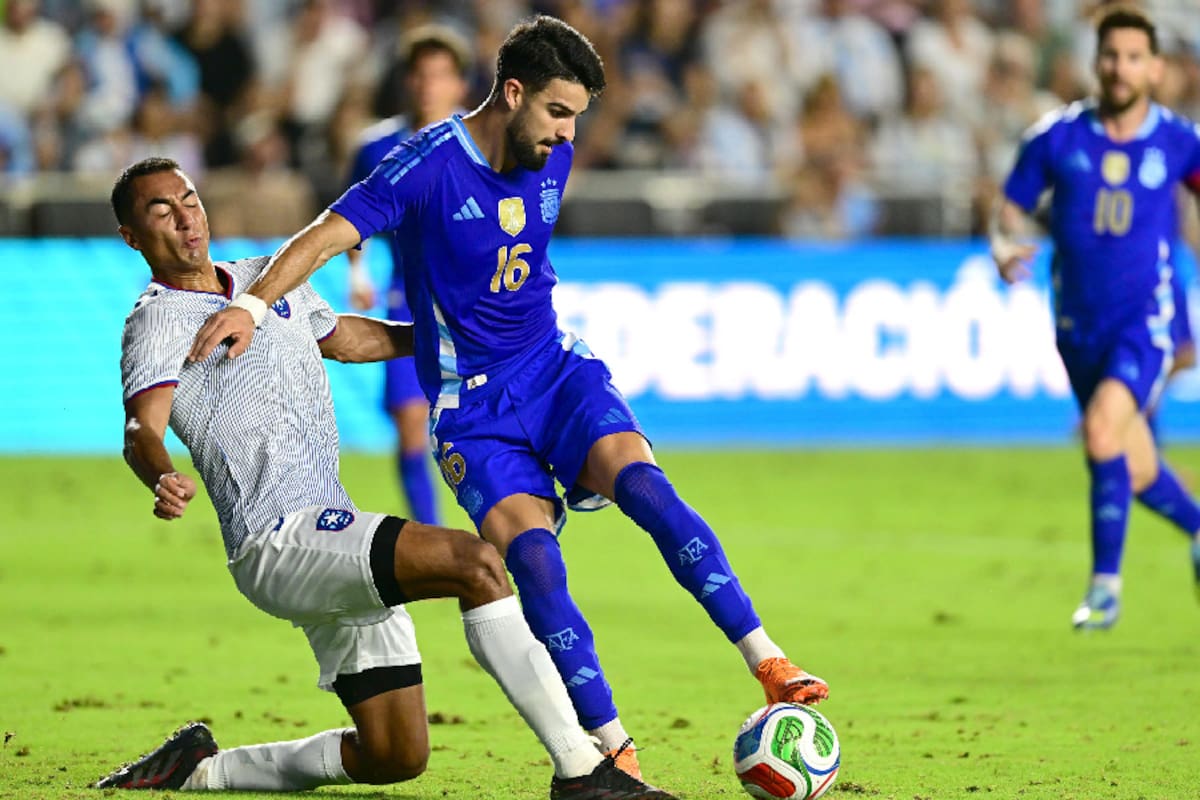 José Manuel 'Flaco' López en su único partido en la selección argentina, el reciente 6-0 a Puerto Rico; detrás de él, Lionel Messi, con quien es "fácil y difícil a la vez" jugar.