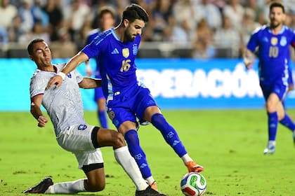 José Manuel 'Flaco' López en su único partido en la selección argentina, el reciente 6-0 a Puerto Rico; detrás de él, Lionel Messi, con quien es "fácil y difícil a la vez" jugar.