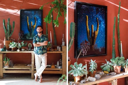 José Pereyra Lucena del otro lado de la cámara, posando frente a una mesa de trabajo antigua que sostiene una fotografía de su serie “Ser*es”, acompañada de cactus y suculentas, una virgen y candelabros.