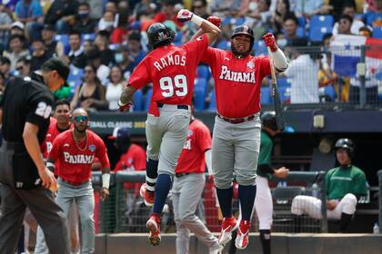 José Ramos (izquierda), de Panamá, salta para celebrar con un compañero tras anotar una carrera en el segundo inning de un juego del Clásico Mundial contra Italia, en Taichung, Taiwán, el 11 de marzo de 2023. (AP Foto/I-Hwa Cheng)