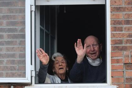 José y Guadalupe saludan desde la ventana de su vivienda luego de haber vencido al Covid-19