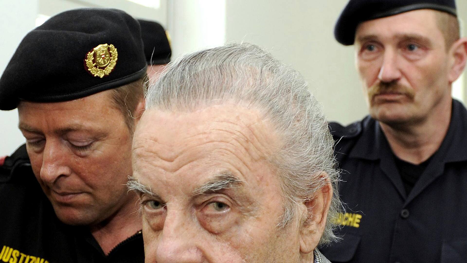 Josef Fritzl llega escoltado por policías al tribunal de St. Poelten, Austria, el 19 de marzo de 2009. Fritzl mantuvo secuestrada a su hija durante 24 años y tuvo siete hijos con ella. (Foto AP/Robert Jaeger, Pool, Archivo)
