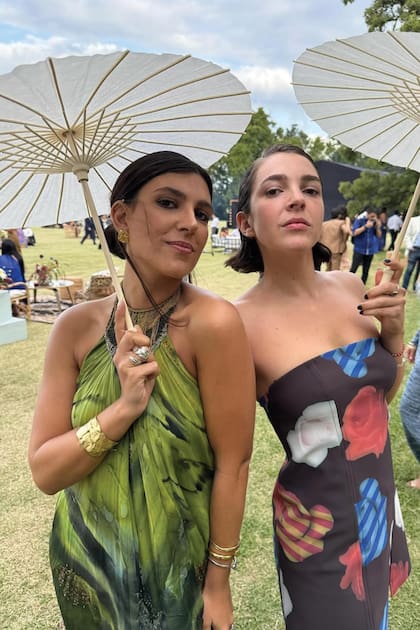 Josefina Vega y Natalie Paniella se protegieron del sol con sombrillas orientales.