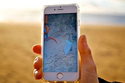 Josette Bernard, muestra su celular con las fotos de los restos de asientos