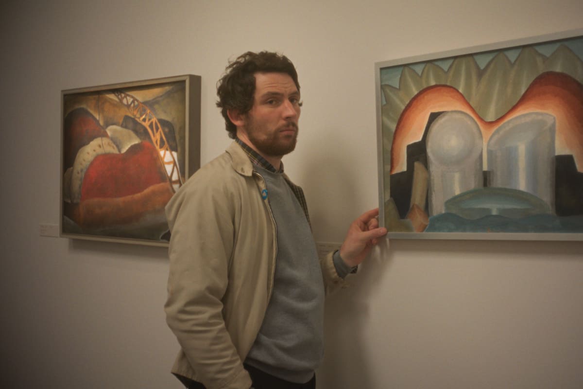 Josh O'Connor con las obras de arte que su personaje planea robar en la trama de Mente maestra, que llegó a los cines argentinos el pasado jueves