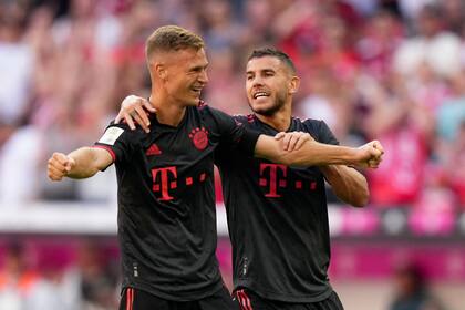 Joshua Kimmich y Lucas Hernández (derecha) celebran el segundo gol del Bayern Múnich ante Wolfsburgo en la Bundesliga, el domingo 14 de agosto de 2022. (AP Foto/Matthias Schrader)