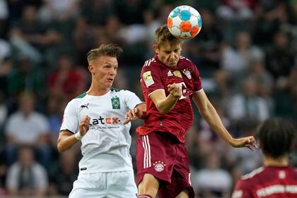 Josip Stanisic, del Bayern Múnich, hace contacto  con el balón mediante la cabeza durante un partido de la Bundesliga, el viernes 13 de agosto de 2021, ante el Borussia Mönchengladbach (AP Foto/Martin Meissner)