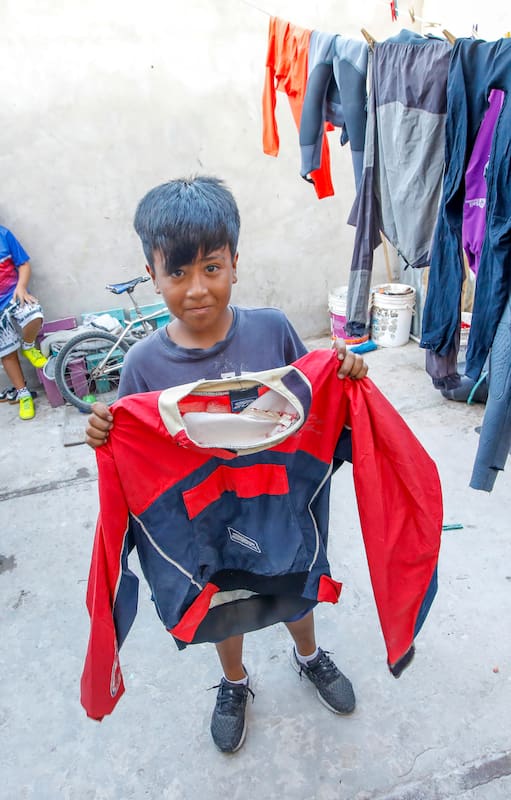 Josué, de 9, vive en La Cava y muestra el traje de navegación con el que entrena navegación