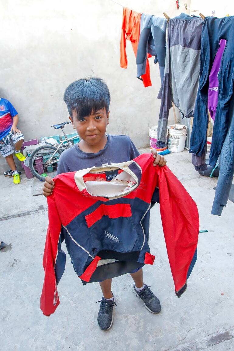 Josué, de 9, vive en La Cava y muestra el traje de navegación con el que entrena navegación
