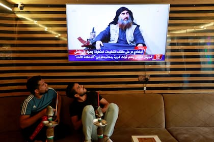 Jóvenes iraquíes ven las noticias de la muerte del líder de Estado Islámico, Abu Bakr al-Baghdadi, en Najaf, Irak, el 27 de octubre de 2019