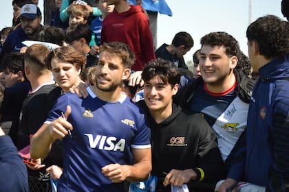 Juan Cruz Mallía se presta a una foto con aficionados a los Pumas en el club CRAI, de Santa Fe, en una de las actividades de contacto con el público que el plantel argentino efectuó en la semana del segundo choque con Australia por el Rugby Championship.