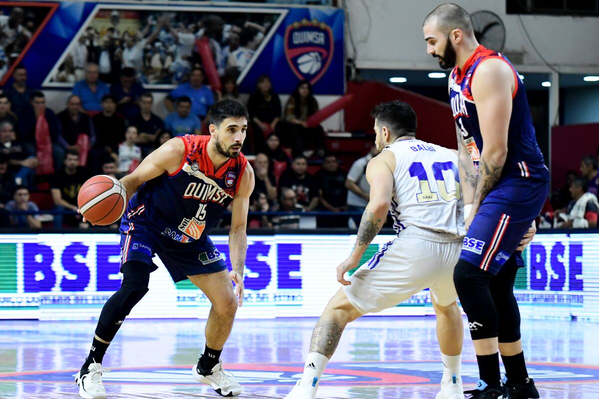 Juan Ignacio Brussino conduce frente al base de Boca, Franco Balbi, con ayuda de Fabián Ramírez Barrios en la cortina; Quimsa fue mejor en el primer capítulo de la final de la Liga Nacional de Básquetbol.