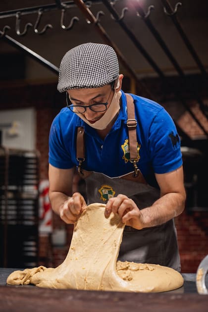 Juan Manuel Alfonso estira la masa de uno de los 1500 panettones de masa madre que elaboró como entrenamiento al mundial.