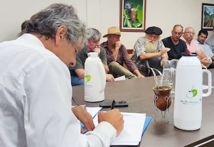 Juan Pazo toma nota de lo que le dice Hugo Sand, el máximo referente de la protesta que en 2001 derivó en la creación del INYM. Un grupo de 15 directores y productores que defienden la regulación se reunieron con el enviado de Luis "Toto" Caputo, quien les sugirió que habría marcha atrás en la designación de Daniel Notta.