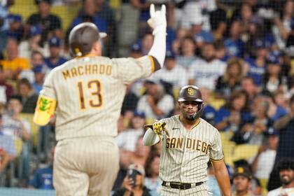 Juan Soto (derecha), de los Padres de San Diego, hace un gesto al bateador designado Manny Machado (16) tras anotar en un jonrón de dos carreras de Machado durante el sexto inning del juego de la MLB que enfrentó a su equipo con los Dodgers de Los Ángeles, el 11 de septiembre de 2023, en Los Ángeles. (AP Foto/Ryan Sun)