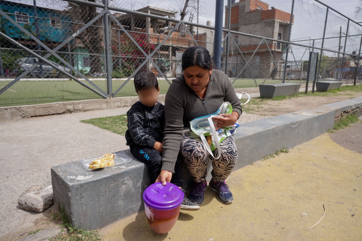 Juana junto a su hijo después de recibir algo de comida en el comedor La Gargantita, en el barrio porteño de Barracas