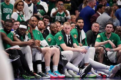 Jugadore de los Celtics de Boston sentados en el banquillo durante los momentos finales de la derrota ante los Mavericks de Dallas en el Juego 4 de las Finales de la NBA, el viernes 14 de junio, en Dallas. (AP Foto/Julio Cortez)