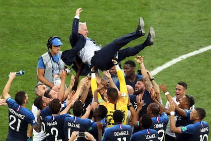 Jugadores de Francia levantan al entrenador, Didier Deschamps, tras vencer a Croacia en la final de Rusia 2018