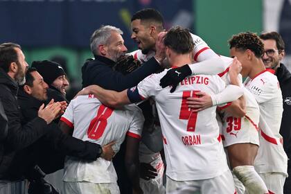 Jugadores de Leipzig celebran con el entrenador Marco Rose después de marcar el tercer gol de su partido de la Copa Alemana entre RB Leipzig y Eintracht Frankfurt, en la Arena Red Bull Arena, en Leipzig, Alemania, el miércoles 4 de diciembre de 2024. (Jan Woitas/dpa via AP)