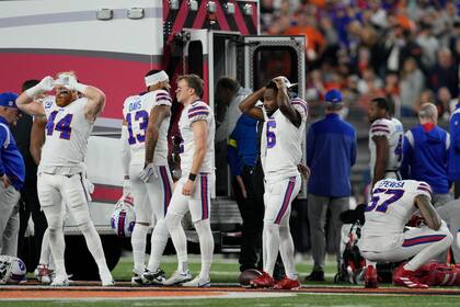 Jugadores de los Bills de Búfalo reaccionan mientras se llevan a su compañero Damar Hamlin en ambulancia tras colapsar en el encuentro ante los Bengals de Cincinnati el lunes 2 de enero del 2023. (AP Foto/Jeff Dean)