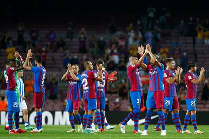Jugadores del Barcelona aplauden a los aficionados al final del partido de La Liga ante la Real Sociedad en el Camp Nou de Barcelona, España, el domingo 15 de agosto de 2021. Barcelona ganó 4-2. (AP Foto/Joan Monfort)