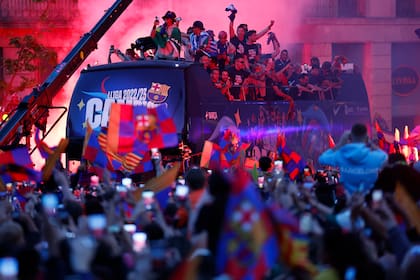 Jugadores del equipo femenino y masculino del Barcelona celebran en un autobus destapado la obtención de los títulos de liga por las calles de la capital catalana, en 2023
