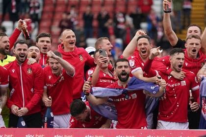 Jugadores del Wrexham celebran en el campo el ascenso del equipo a la League One al fial del encuentro ante Forest Green el sábado 13 de abril del 2024. (Jacob King/PA via AP)