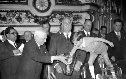 Jules Rimet sostiene el copón de vidrio para que su nieto retire las bolillas durante el sorteo del Mundial de Francia en 1938
