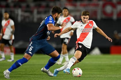 Julián Álvarez controla pelota ante la marca de De los Santos