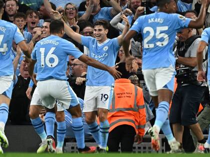 Julián Álvarez ríe, sus compañeros van a buscarlo. Transita su segunda temporada en Manchester City
