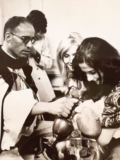 Julieta en brazos de su madrina el día de su bautismo (1972) en la parroquia San Benito Abad. Atrás, sus padres, Evangelina Salazar y Ramón Ortega.