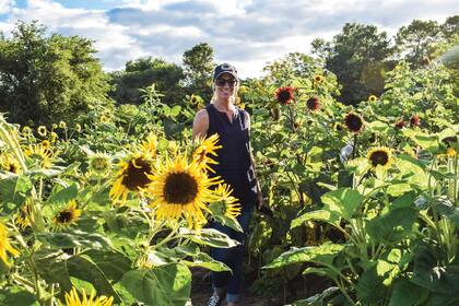 Julieta Firpo rodeada de estas emblemáticas flores. El cultivo va creciendo, no solo en cuanto al espacio, sino también a las variedades que siguen incorporando.