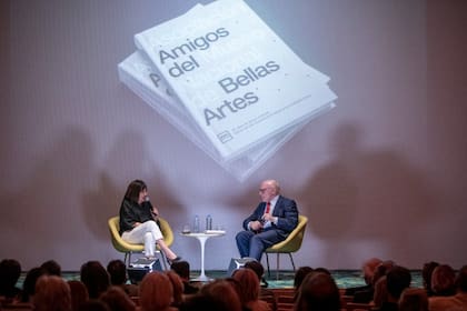 Julio César Crivelli entrevistado por Cristina Mucci, ante un auditorio lleno; detrás, el libro de la Aamnba