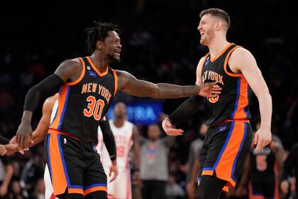 Julius Randle (30) e Isaiah Hartenstein, de los Knicks de Nueva York, festejan en el duelo ante los Nets de Brooklyn, el miércoles 1 de marzo de 2023 (AP Foto/John Minchillo)