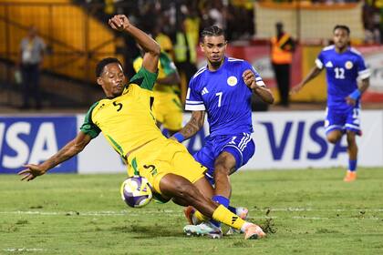 Juninho Bacuna, de Curazao, al centro, lucha por el balón contra Ethan Pinnock, de Jamaica; los Reggae Boyz acudirán al repechaje (AP Photo/Collin Reid)