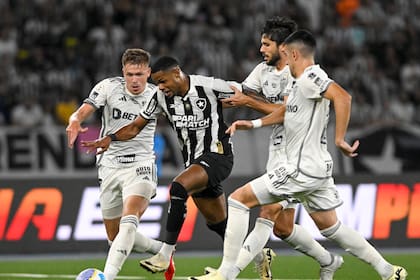 Junior Santos, de Botafogo, intenta pasar con la pelota ante la marca de tres jugadores de Mineiro; se verán las caras el sábado a las 17 en el Monumental, por la final de la Copa Libertadores