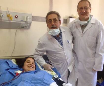 Junto a dos de los médicos que le salvaron la vida.