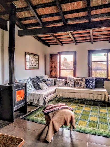 Junto a la cocina, dos camas funcionan como sillón o cuarto según la necesidad. La salamandra (Tromen) y la chimenea son la mejor calefacción.