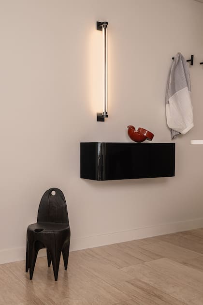 Junto a la puerta de ingreso colocaron un mueble flotante (Siuk Studio) y un perchero para poder dejar los objetos cotidianos. Silla (Marcelo Federico), pieza esmaltada (Carolina Iotti). Lámpara vertical (Huup).