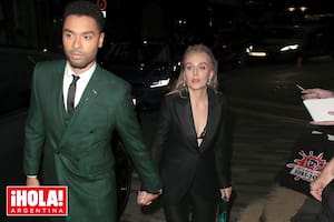 Junto a su novia, Emily Brown, con looks combinados: él vistió un elegante traje de chaqueta color verde botella, y ella un traje sastre negro con una cartera de mano verde, que parecía elegida para estar a juego con Regé-Jean
