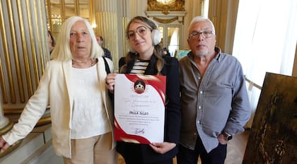 Junto a sus padres, recibiendo un reconocimiento.